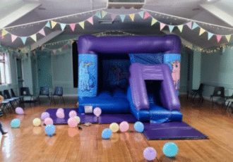 A large blue and purple bouncy castle in a hall