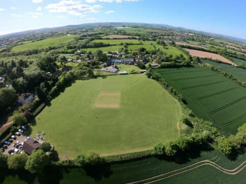 An aerial photo showing Nynehead Cricket pitch, and the rolling green fields beyond.