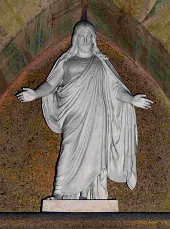 A beautiful porcelein sculpture of Jesus Christ, his arms wide and welcoming in a symbolic pose.